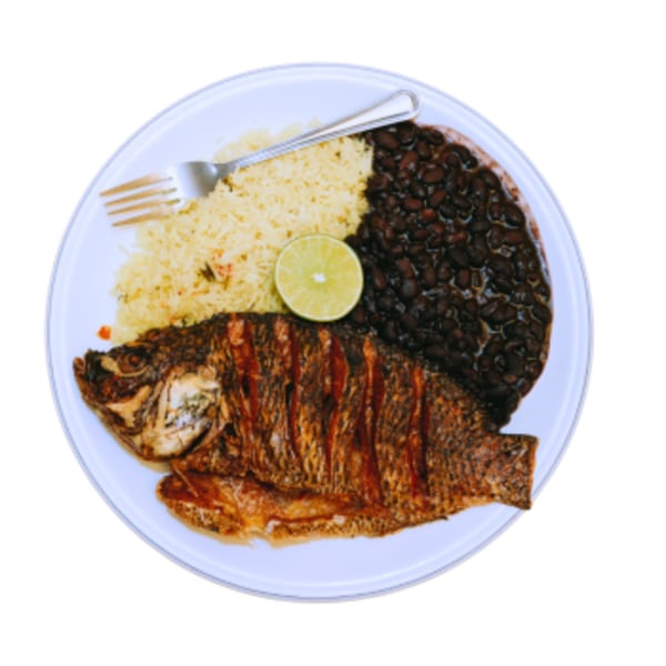 A fried whole fish, yellow rice, and black beans with a lime wedge on a white plate.